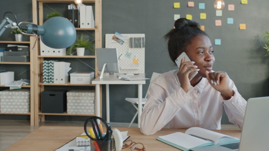 Femme au téléphone devant son ordinateur dans un bureau